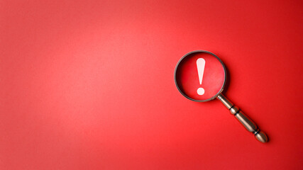 magnifier magnifying exclamation mark on red background. alert and precaution concept. caution and r