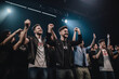 © Denis Yevtekhov - A portrait of a professional gamer with their team, all smiling and raising their hands in unison to commemorate a win Generative AI