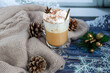 Hot coffee latte with cinnamon sticks, sprinkled with cinnamon. Christmas decorations, branches of a Christmas tree. Holiday concept New Year.