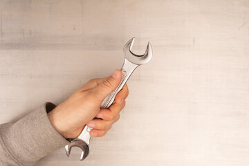 Poster -  Wrench in hand closeup on white background