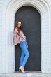 © Andrey_Arkusha - Portrait of a young beautiful brunette girl in blue jeans posing in a stone arch