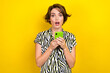 Photo of impressed astonished cute girl with hold smartphone facebook twitter instagram whatsapp isolated on yellow color background