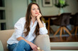 © sepy - Portrait of an attractive young woman relaxing in an armchair at home and daydreaming