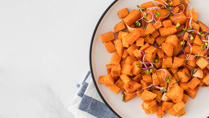 Wall Mural - Baked sweet potato slices in a plate on the table. Healthy eating. Vegan dish. Copy space