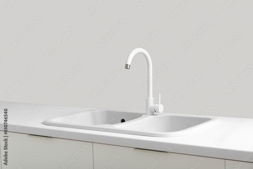 White sink with faucet in light kitchen