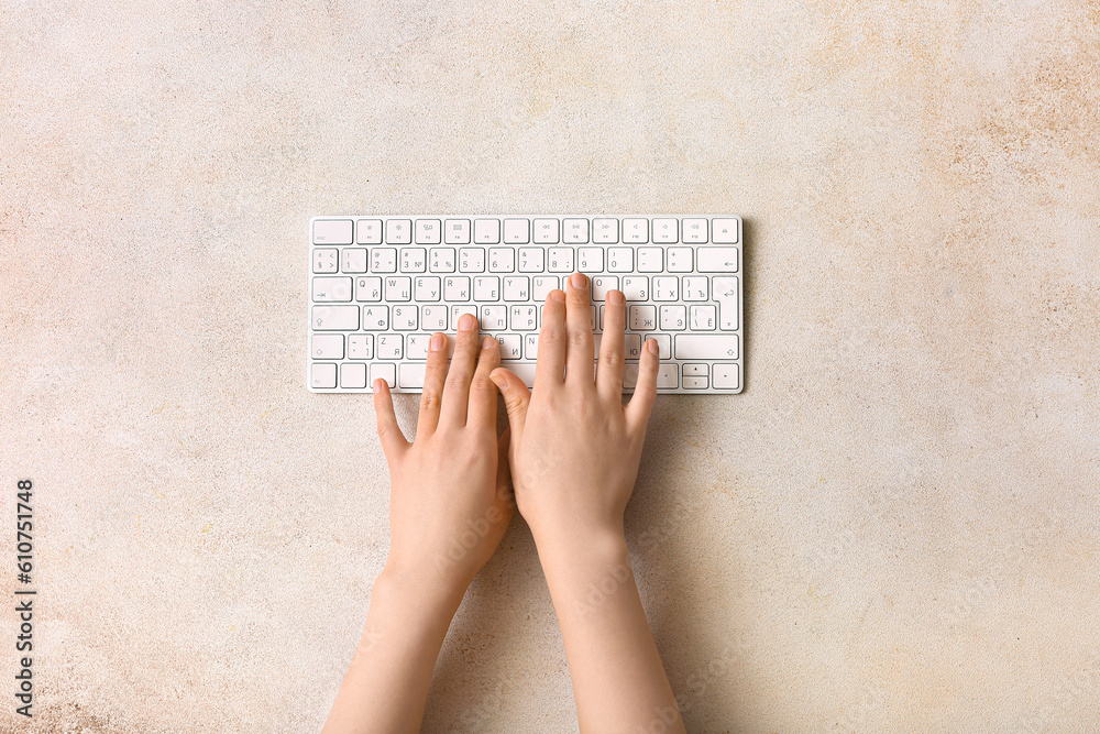 Female hands with modern computer keyboard on light background