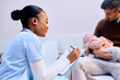 © Drazen - Happy black nurse filling medical paperwork of father and his baby at pediatric clinic.