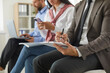 © Studio Romantic - Business people working in office. Cropped shot of man in suit and tie sitting on chair, holding clipboard in hand and writing something while others are using laptops and mobile phones in background