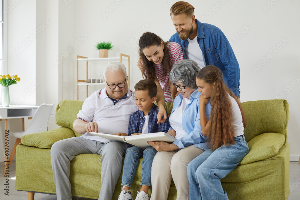 Family looks at photo album together and remembers stories from past ...