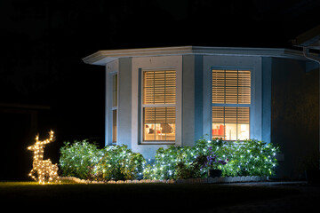 Brightly illuminated christmas decorations on front yard of florida family home. Outside decor for winter holidays