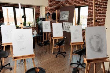 Creative leisure activities and group art classes, drawing academy interior. Empty art school interior with wooden easels standing in row, no people. Pencil sketching lessons, visual arts education