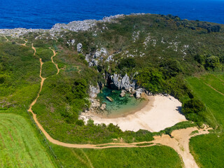 Aerial view, Playa de Gulpiyuri, flooded sinkhole with inland beach near Llanes, in Asturias Northern Spain, around 100 m from Cantabrian Sea, the shortest beach in the world