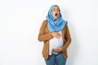 Young beautiful pregnant muslim woman wearing hijab over white background yawns with opened mouth stands. Daily morning routine