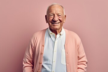 Medium shot portrait photography of a grinning man in his 80s that is wearing a chic cardigan against a pastel or soft colors background .  Generative AI