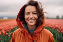 Medium Shot Portrait Photography Of A Grinning Woman In Her 30s That Is Wearing A Warm Parka Against A Beautiful Tulip Field In Full Bloom With A Windmill Background .  Generative AI