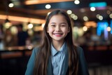Fototapeta  - Portrait of a smiling little girl in a cafe looking at camera