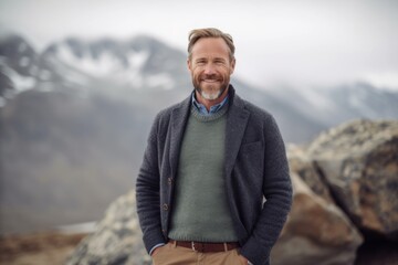 Portrait of a handsome mature man standing on top of a mountain