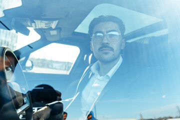 Poster - Young businessman in elegant suit driving luxury car