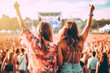 Two women enjoying a concert at a music festival. Back view