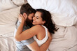 © Emil Lime/peopleimages.com - Home bedroom, affection and happy couple hug, relax and enjoy relax morning together, bonding and smile. Happiness, intimate and top view of romantic woman, man or people embrace on hotel bed fabric
