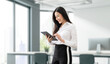 © NAMPIX - Beautiful businesswoman using laptop standing in office.