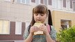 little girl schoolgirl eats sandwich, eat school, children delicious snack, kid food, healthy children's food, school education kid, girl daughter outdoors eats sausage bread, digestion, good health
