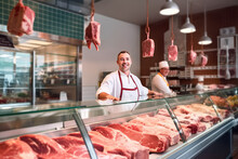 Man Standing In Front Of Shelves With Raw Meat. Male Butcher Or Shopkeeper Working In Modern Meathsop. Generative AI