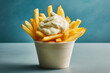 tasty and crunchy french fries in a box with mayonnaise on a blue wall, created with generative ai