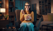 Expressive Woman Watching TV And Eating Popcorn