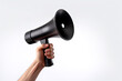 © dewaai - The hand holds a black megaphone on white background. Announcement concept. Shout It Out