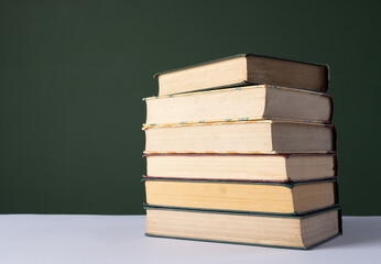 Poster - Close up of stack of books with copy space on green background