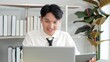 © M Stocker - Happy young asian businessman working on laptop on desk in office. Smart and professional young Asian businessman. Freelancer