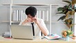 © M Stocker - Young Asian man tired eyes from hard work. Young man tired feeling eyestrain stressed working from laptop. Suffers eyesight problem after using laptop for working long time