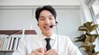 © M Stocker - Portrait young asian businessman call center wearing headset. businessman in headphones talk speak on video call in office with business client. Digital virtual conference