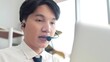 © M Stocker - Young asian man call center worker in headphones working and communication, customer service, video call support customer