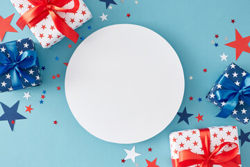 American Independence Day gift themes. Top view flat lay of gift boxes in national colors, patriotic sparkles on light blue background with blank circle for greeting or promotion text