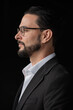 © Ranta Images - Profile view portrait of handsome businessman against black background wearing eyeglasses
