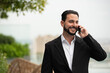 © Ranta Images - Portrait of handsome businessman outdoors at rooftop talking on mobile phone