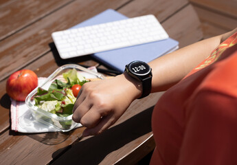  A female office worker checks the lunch time and tries to start eating