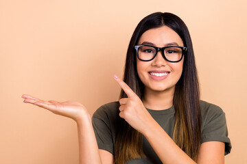 Wall Mural - Photo of charming student girl wear khaki t-shirt direct finger empty space object for comfortable studying isolated on beige background