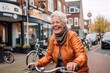 © Markus Schröder - Environmental portrait photography of a happy mature woman riding a bike against a lively pub background. With generative AI technology