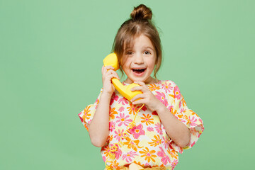 Wall Mural - Little child kid girl 6-7 years old wearing casual clothes have fun talk speak on handset phone , isolated on plain pastel green background studio portrait. Mother's Day love family lifestyle concept.