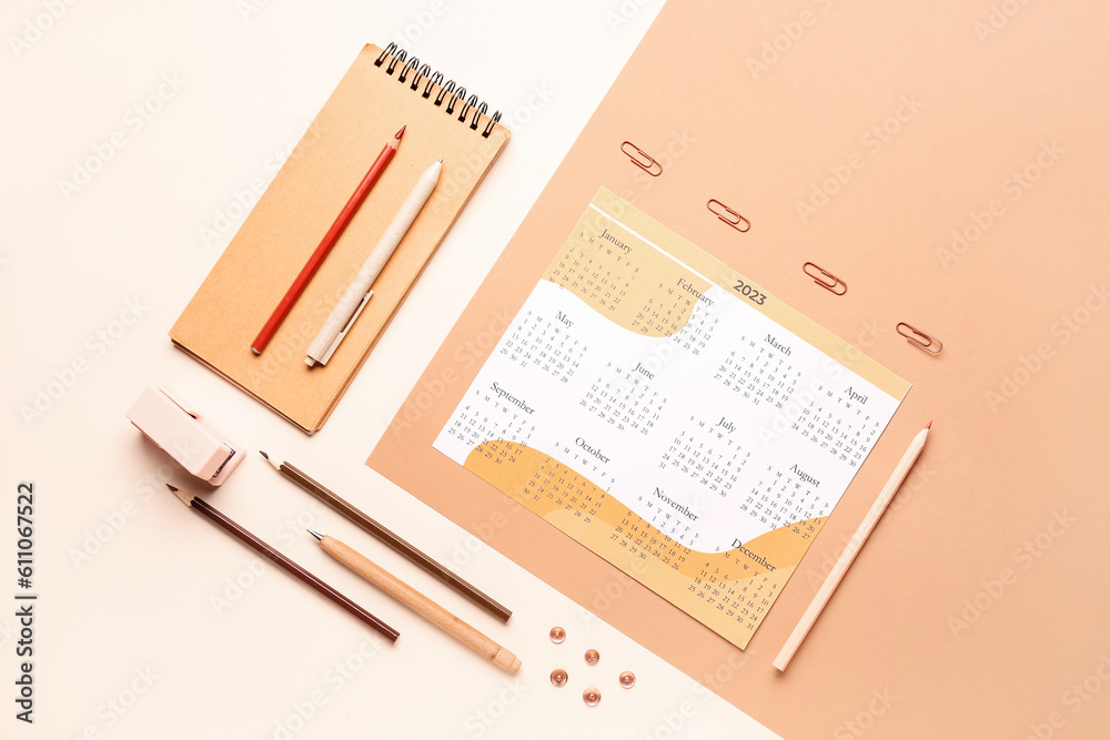 Composition with calendar, notebook, pencils and stationary on beige background