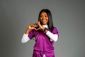 cheerful african nurse excited and isolated in a background showing a love sign