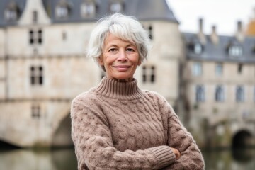 Wall Mural - Medium shot portrait photography of a glad mature woman wearing a cozy sweater against a medieval castle background. With generative AI technology