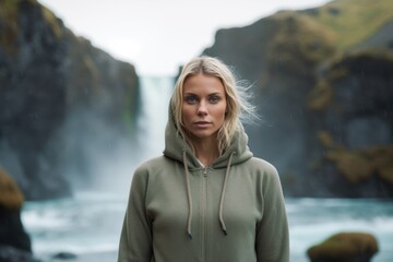 Poster - Medium shot portrait photography of a satisfied girl in her 30s wearing a comfortable hoodie against a majestic waterfall background. With generative AI technology