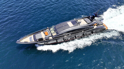 Aerial drone photo of small luxury yacht with wooden deck cruising in high speed deep blue Mediterranean sea