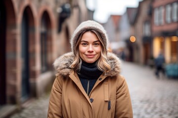 Wall Mural - Studio portrait photography of a satisfied girl in her 30s wearing a cozy winter coat against a picturesque old town background. With generative AI technology