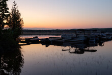 Selective Focus View Of Pontoons And Boats Docked In Lovering Lake Seen At Sunrise During A Beautiful Sunrise In Spring, Magog, Quebec, Canada