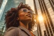 © Adriana - Happy wealthy rich successful black businesswoman standing in big city modern skyscrapers street on sunset thinking of successful vision, dreaming of new investment opportunities. Generative AI